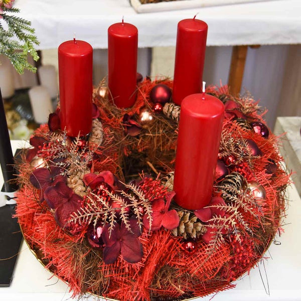 Adventskranz mit roten Kerzen, Tannenzapfen und Weihnachtskugeln