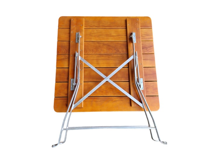 Klapptisch aus Holz von unten mit Metallgestell und Scharniermechanismus.