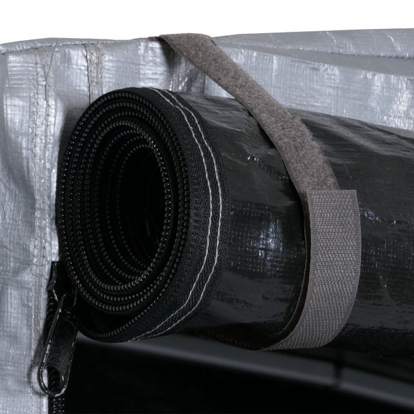 Detailansicht einer aufgerollten Gewächshaustür, befestigt mit einem Klettband, daneben ein geöffneter Reißverschluss.
