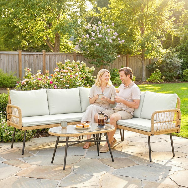 Ein Paar entspannt in einem modernen Garten-Lounge-Set aus Geflecht mit Ecksofa und Couchtisch auf einer hellen Holzterrasse.