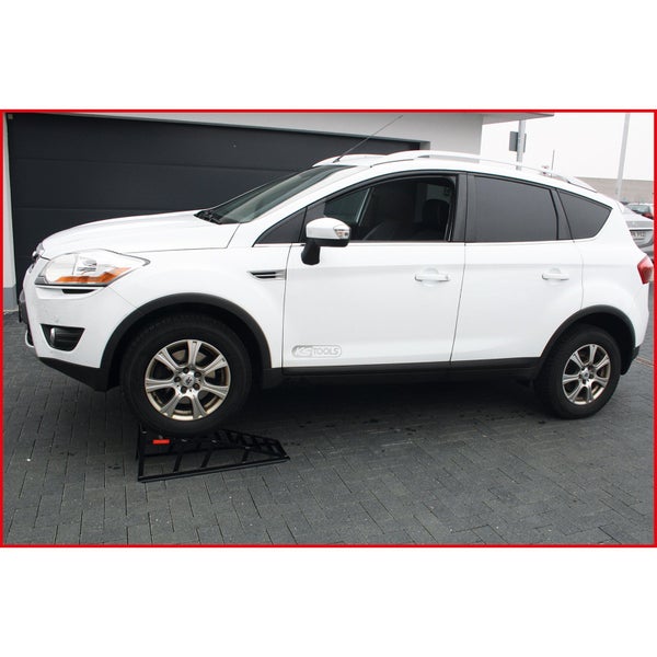 Ein Auto fährt auf eine Kfz-Auffahrrampe.