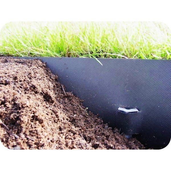 Detailaufnahme einer Rasenkante aus Kunststoff zwischen Rasen und Erde, befestigt mit einem Hering.