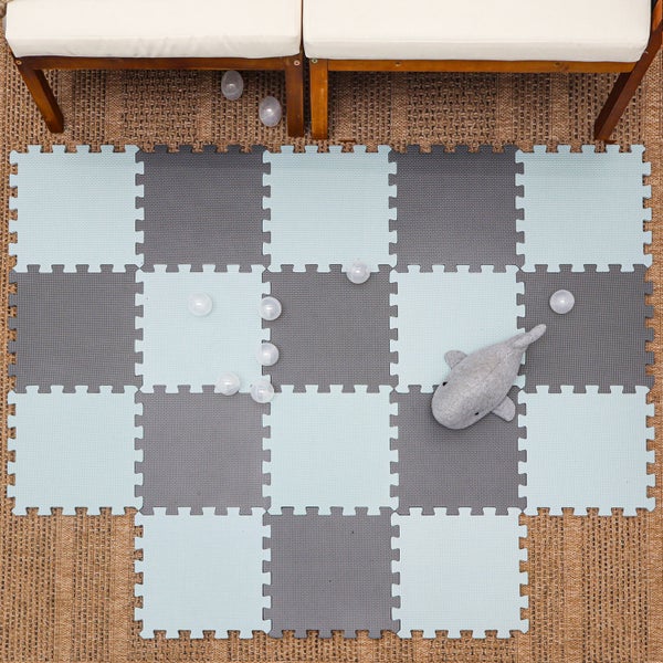 Puzzlematte aus weichen Schaumstoff-Fliesen im Schachbrettmuster für das Kinderzimmer. Mit Stofftier und Spielbällen auf einem Teppich.