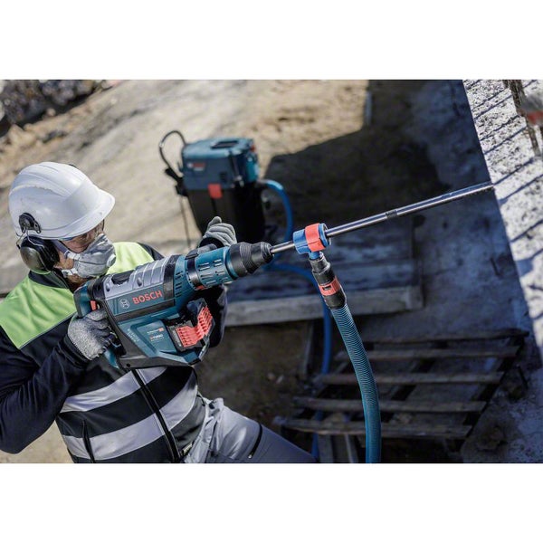 Ein Arbeiter mit einem Bosch Bohrhammer mit Staubabsaugung bohrt in Beton.