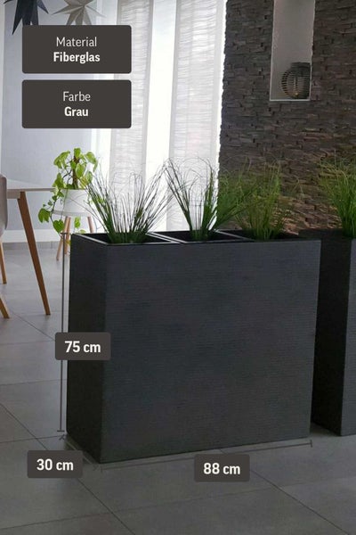 Grauer, rechteckiger Pflanzkübel aus Fiberglas, 88 x 30 x 75 cm, mit Gräsern in einem modernen Raum mit Steinwand.