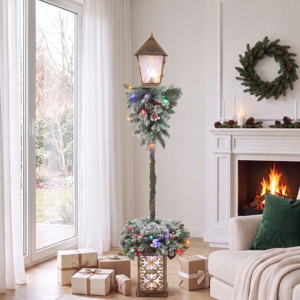 Dekorative Weihnachts-Laterne als Stehlampe mit künstlichem Tannengrün, Lichterkette und Geschenken in einem weihnachtlich geschmückten Wohnzimmer.