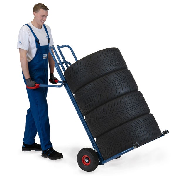 Mann transportiert Reifen auf einer Sackkarre