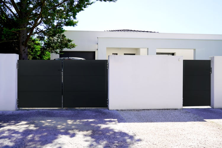 Schiebetor aus Metall vor einem modernen Wohnhaus