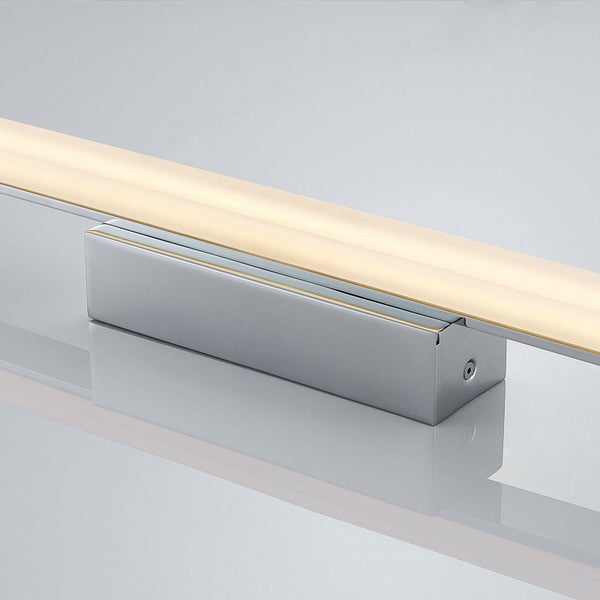 Lineare LED-Spiegelleuchte aus silbernem Metall mit rechteckigem Sockel und warmweißem Licht.