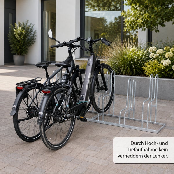 Fahrradständer aus Metall mit Hoch- und Tiefaufnahme zur platzsparenden Lagerung von zwei Fahrrädern vor einem modernen Wohnhaus.