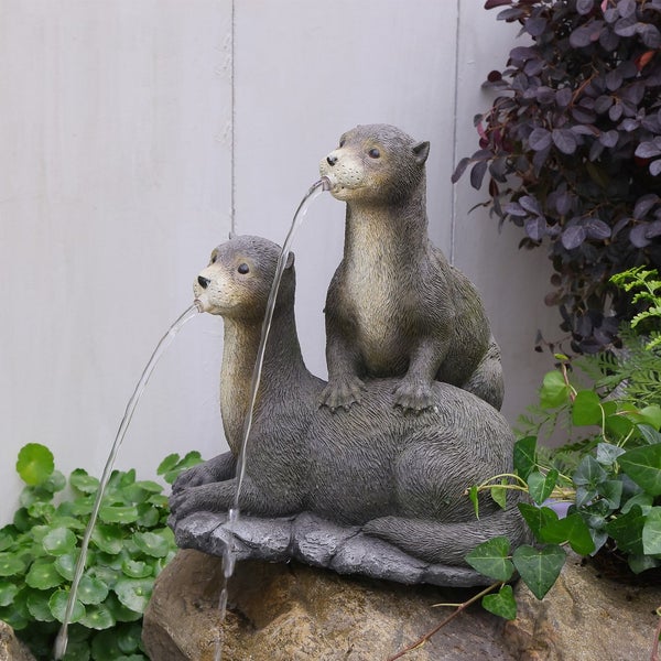 Gartenbrunnen aus Polyresin mit zwei Ottern, aus deren Mäulern Wasser spritzt. Dekorative Teichfigur für den Außenbereich.