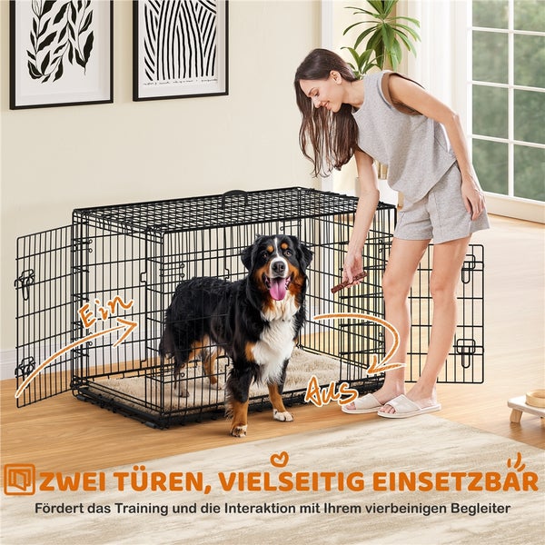 Schwarze Hundebox mit zwei Türen und einer Frau, die ihrem Hund ein Leckerli gibt.