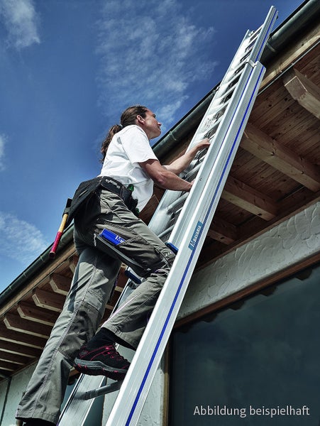 Handwerker steigt auf einer Aluminiumleiter an einer Hausfassade empor.