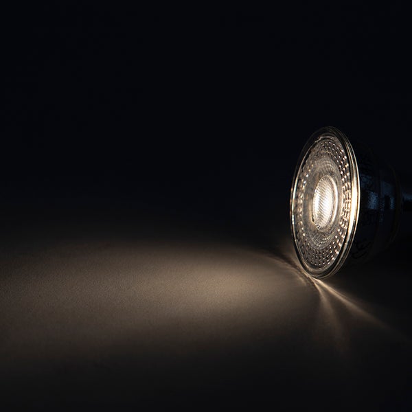 Silberfarbenes LED-Leuchtmittel mit GU10-Sockel in Reflektorform.