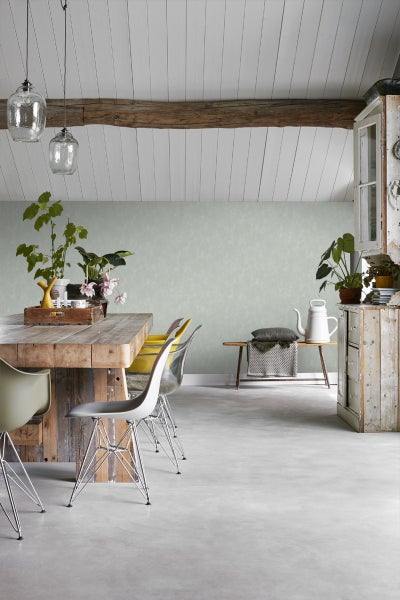 Helles Esszimmer mit Holztisch, Stühlen und Dekorationspflanzen