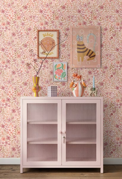 Vliestapete mit floralem Muster aus kleinen Blumen und Blättern, kombiniert mit einer Anrichte und Wanddekoration im verspielten Stil.