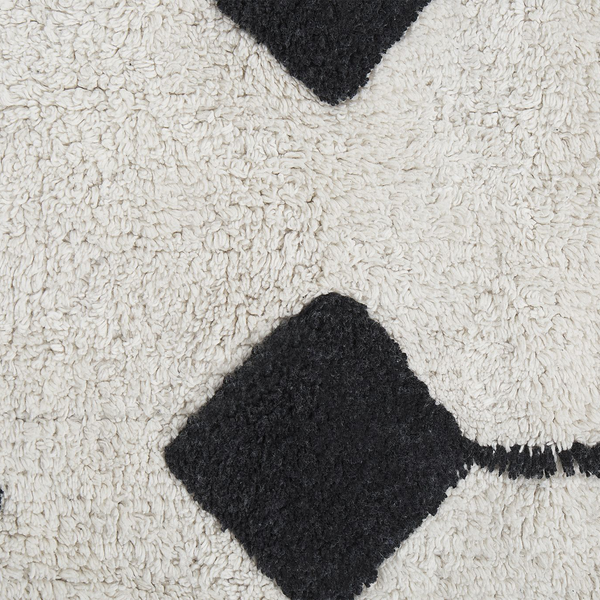 Detail eines Hochflor-Teppichs mit geometrischem Rautenmuster.