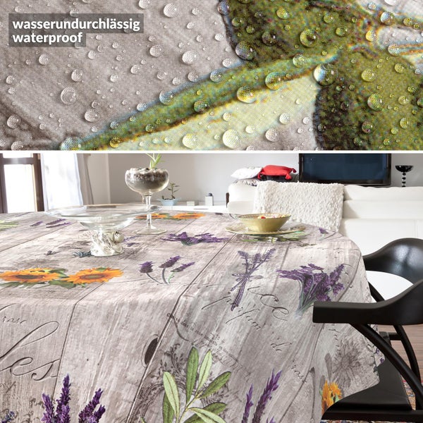 Wasserdichte runde Tischdecke mit Lavendel- und Sonnenblumenmotiven in Holzoptik, Detailansicht von Wassertropfen auf der Oberfläche.