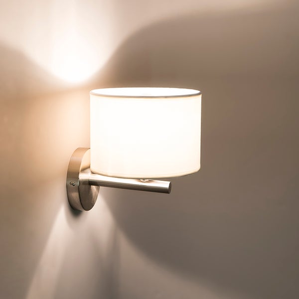 Wandleuchte mit zylindrischem Textilschirm und Metallarm.