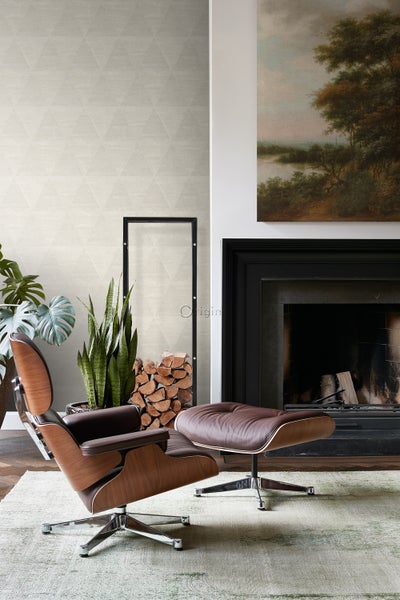 Wohnzimmer mit Sessel, Kamin und dekorativer Wandtapete mit Dreiecksmuster