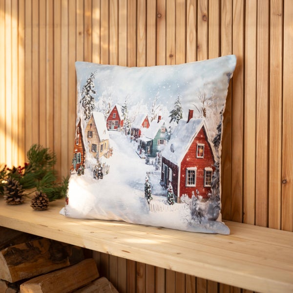 Zierkissen mit Winterdorf Motiv auf einem Holzregal vor einer Holzlamellenwand.