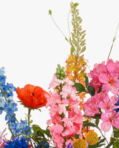 Bunter Kunstblumenstrauß mit verschiedenen Blüten wie Pfingstrosen und Kornblumen in einer grünen Keramikvase.