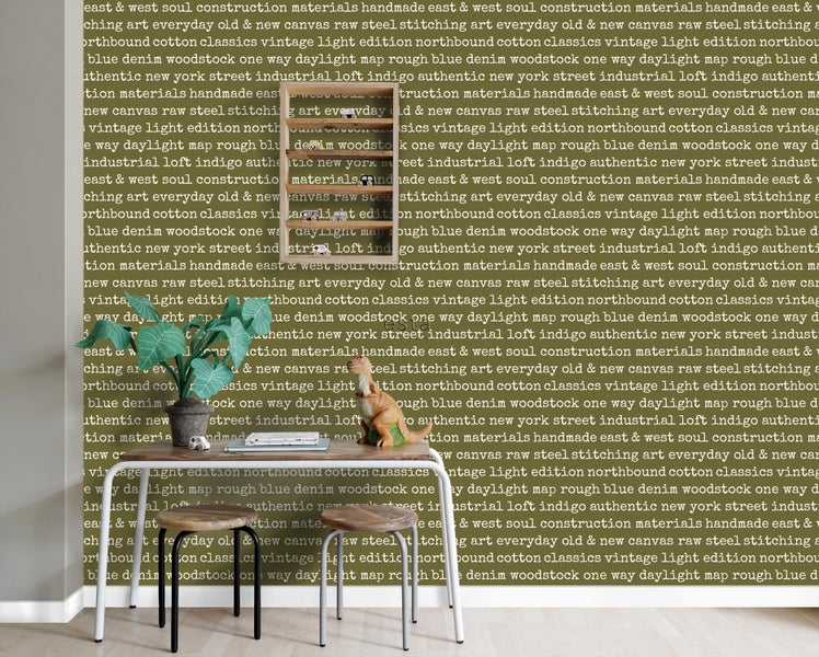 Dekoratives Zimmer mit Tisch, Pflanze und Accessoires vor einer gemusterten Tapete