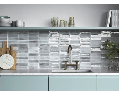 Küchenszene mit grauen, rechteckigen Fliesen an der Wand über der Arbeitsplatte