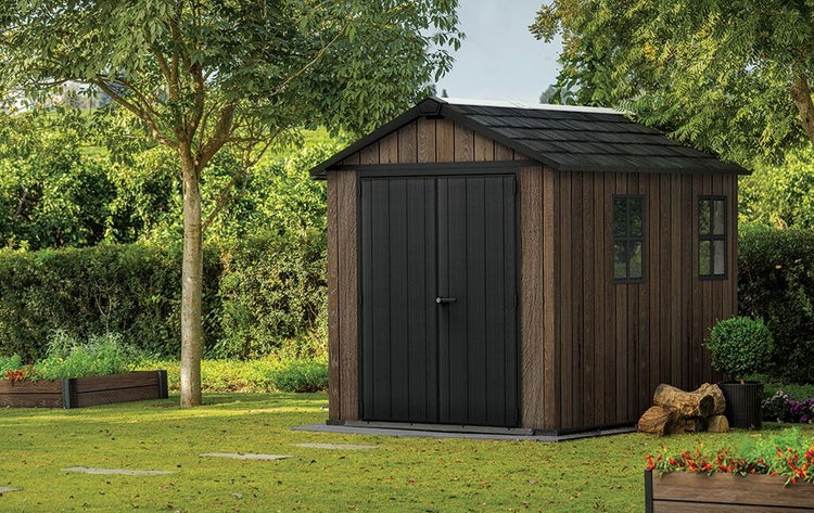 Geräteschuppen aus Holz mit Doppeltür und Fenster im Garten.