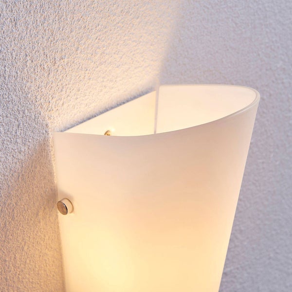 Eingeschaltete Wandleuchte aus satiniertem Glas mit warmem Licht an einer strukturierten Wand.