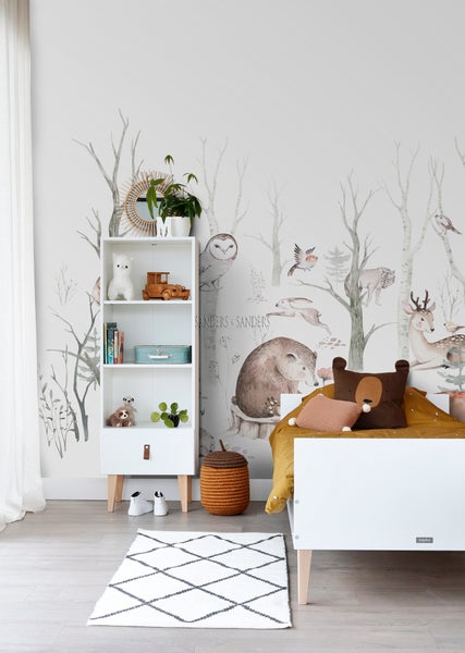Kinderzimmer mit Waldtiertapete, weißem Bett, Regal und geometrischem Teppich
