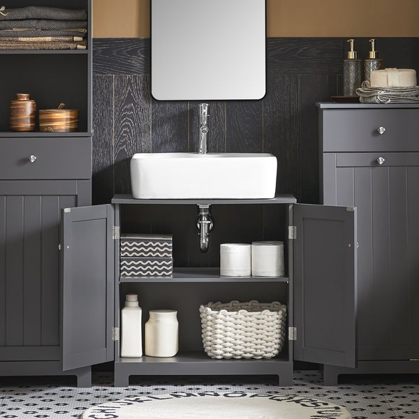 Badezimmeransicht mit Waschbecken, Spiegel und Stauraummöbeln in dunklem Farbton