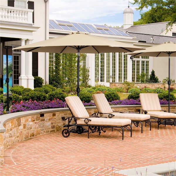 Szene im Freien mit Sonnenschirmen und Liegestühlen auf einer Terrasse vor einem Haus