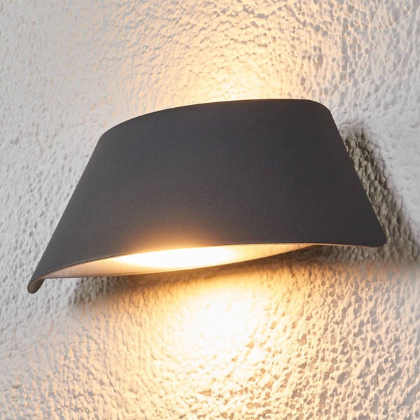 Moderne LED-Außenwandleuchte in Anthrazit mit gebogenem Gehäuse und Lichtaustritt nach oben und unten an einer strukturierten Wand.