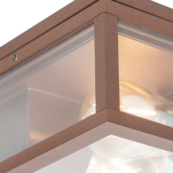 Detailansicht einer Außenleuchte mit rostfarbenem Metallrahmen und klaren Glaspaneelen inklusive leuchtender Glühbirne.