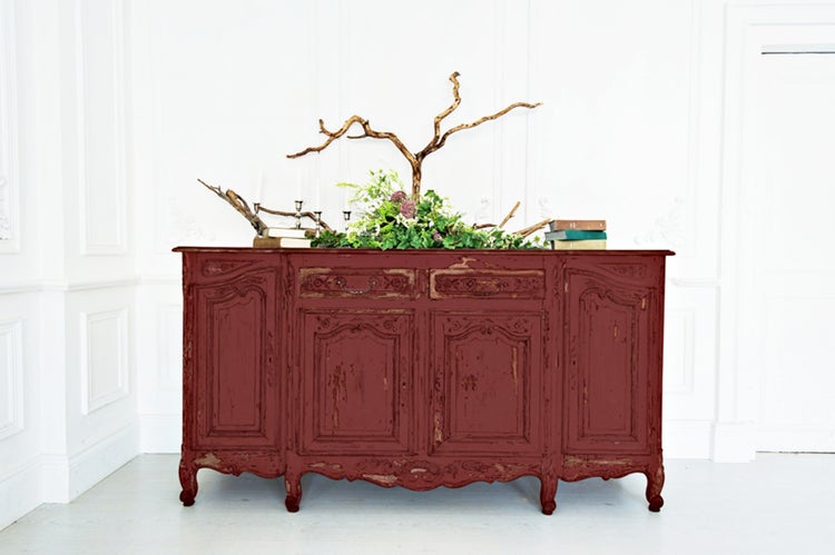 Rustikaler Schrank mit vier Türen und zwei Schubladen, dekoriert mit Blumen, Zweigen und Büchern.