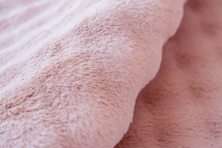 Nahaufnahme eines weichen, rosafarbenen Kunstfells mit flauschiger Textur.