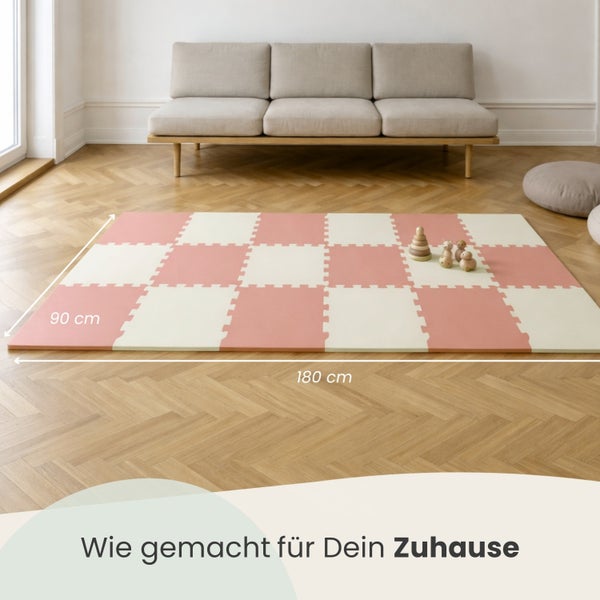 Helle Raumgestaltung mit rosa und weiß karierter Puzzlematte auf Parkett, 90 mal 180 Zentimeter, mit modernem Sofa und Spielzeug im Hintergrund.