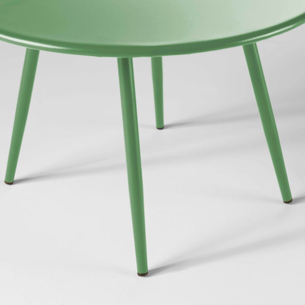 Grüner Beistelltisch aus Metall mit runder Tischplatte und vier schlanken Tischbeinen.