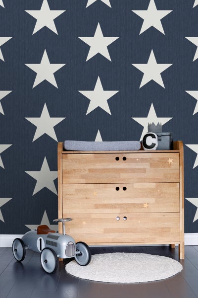 Kinderzimmer mit Sternenmuster-Tapete, Wickelkommode aus Holz und Spielzeugauto