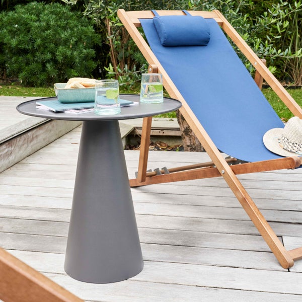 Moderner runder Beistelltisch aus Metall in Anthrazit auf einer Holzterrasse neben einem hölzernen Liegestuhl mit blauem Stoffbezug.