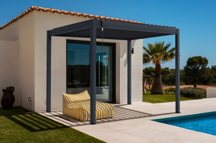 Freistehende anthrazitfarbene Aluminium-Pergola mit Lamellendach auf einer hellen Terrasse neben einem Pool.