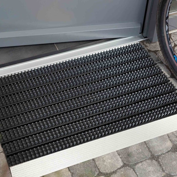 Fußmatte mit Bürstenprofil vor einer Tür