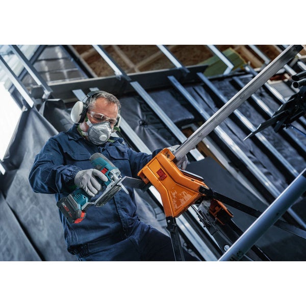 Handwerker schneidet Metallprofil mit einer Akku-Blechschere in einer Werkstatt.