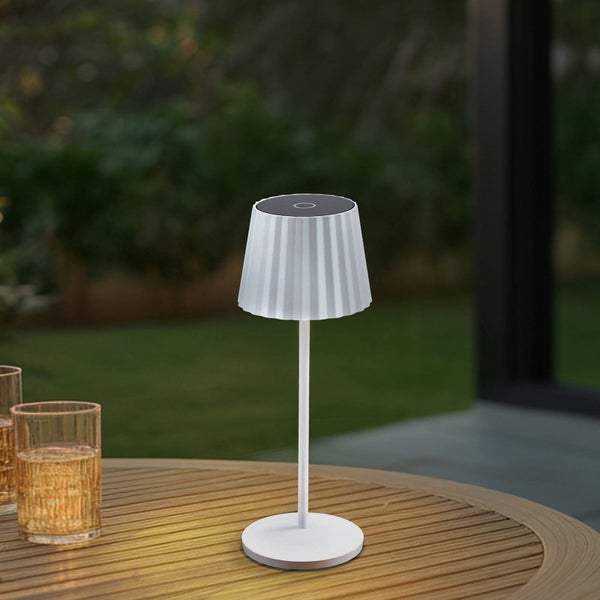 Moderne Solar-Tischleuchte für den Außenbereich auf einem Holztisch, weiß mit plissiertem Schirm.