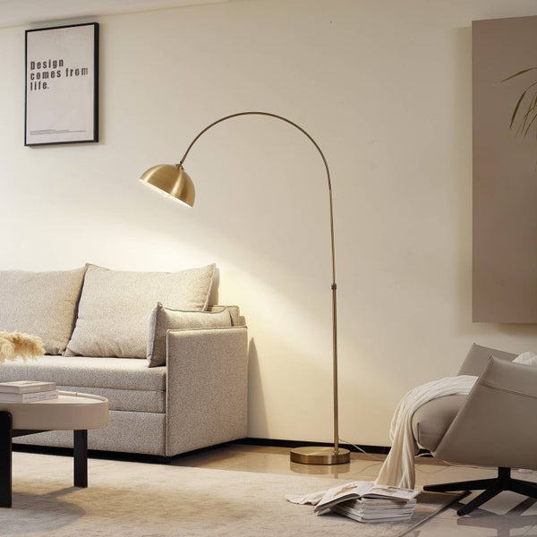 Wohnzimmer mit Sofa, Sessel und goldfarbener Stehlampe.