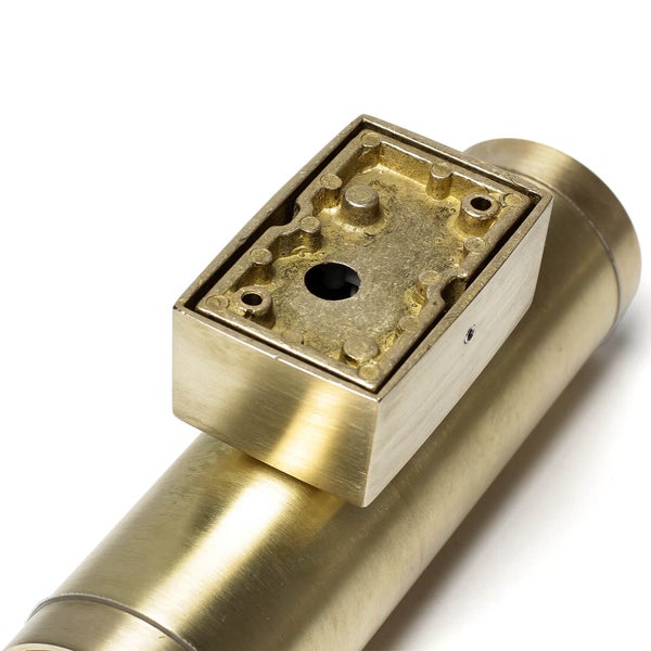 Detailaufnahme eines rechteckigen, messingfarbenen Abflussrohrs