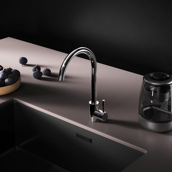 Spültischarmatur aus Chrom neben einer Schale mit Feigen und einem Wasserkocher auf einer Arbeitsplatte