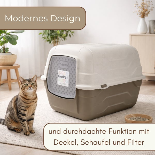Geschlossene Haubentoilette für Katzen mit Schwingtür und Tragegriff in einem hellen Raum neben einer Katze inklusive Schaufel und Filter.