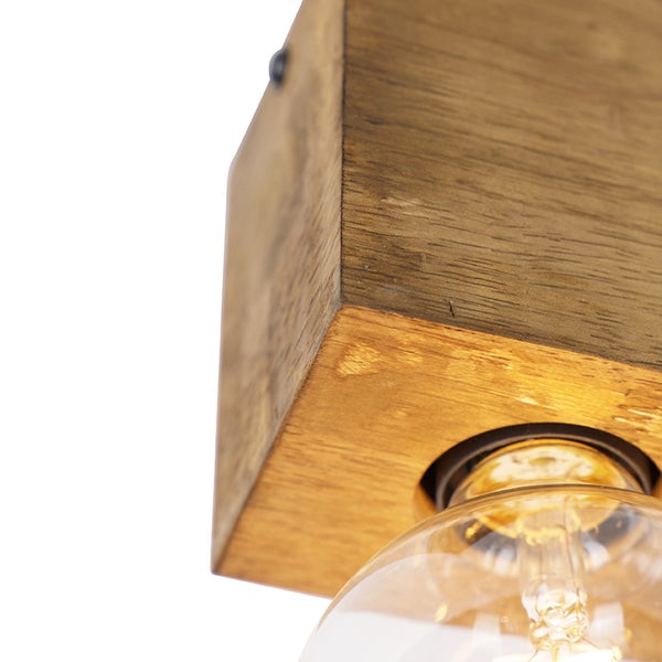 Detailansicht einer Deckenleuchte mit Holzsockel und Glühbirne